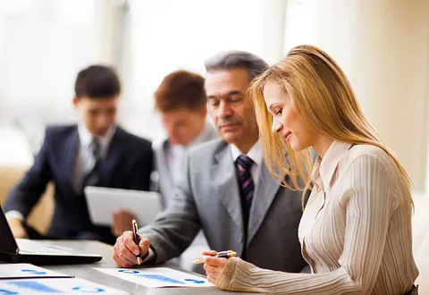 Two people looking over a document together representing the trusted advisors of business plan providers OSGroup in West Windham, NH